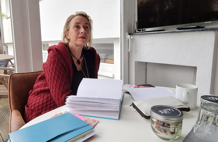 Sabine am Tisch mit dem ausgedruckten Manuskript